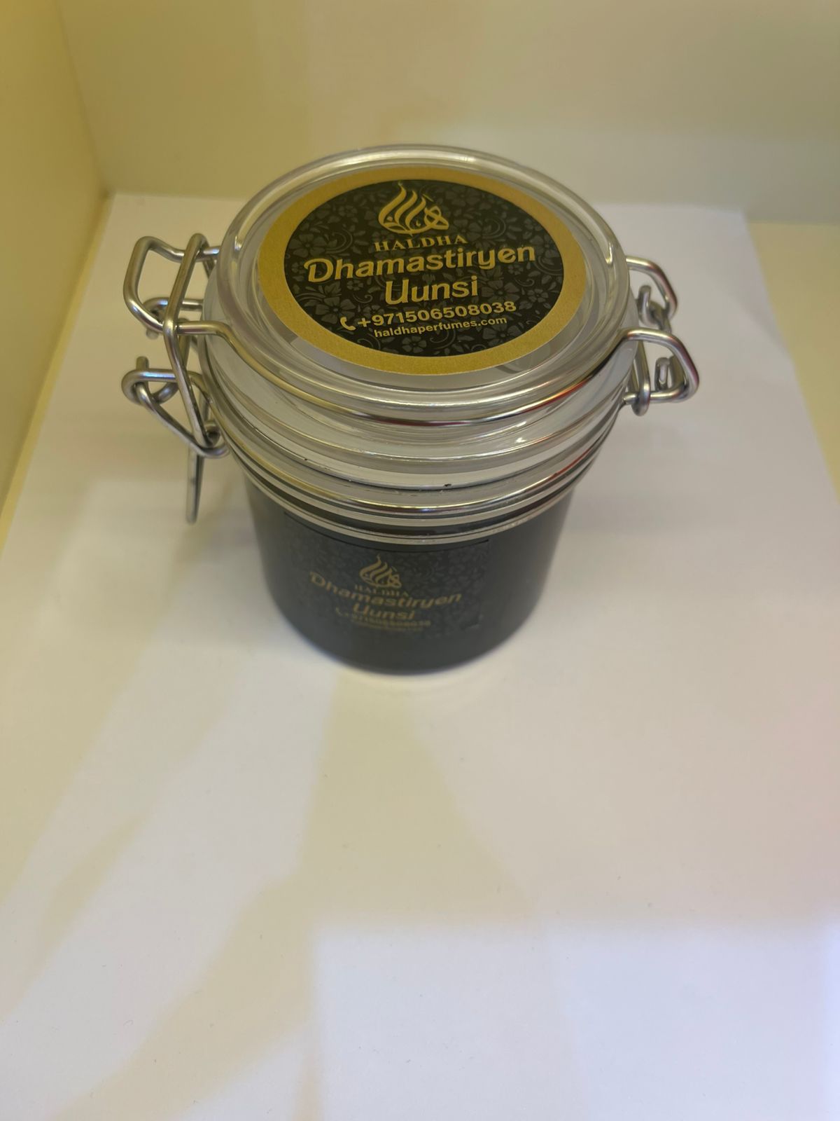 Black container with a silver lid on a white surface