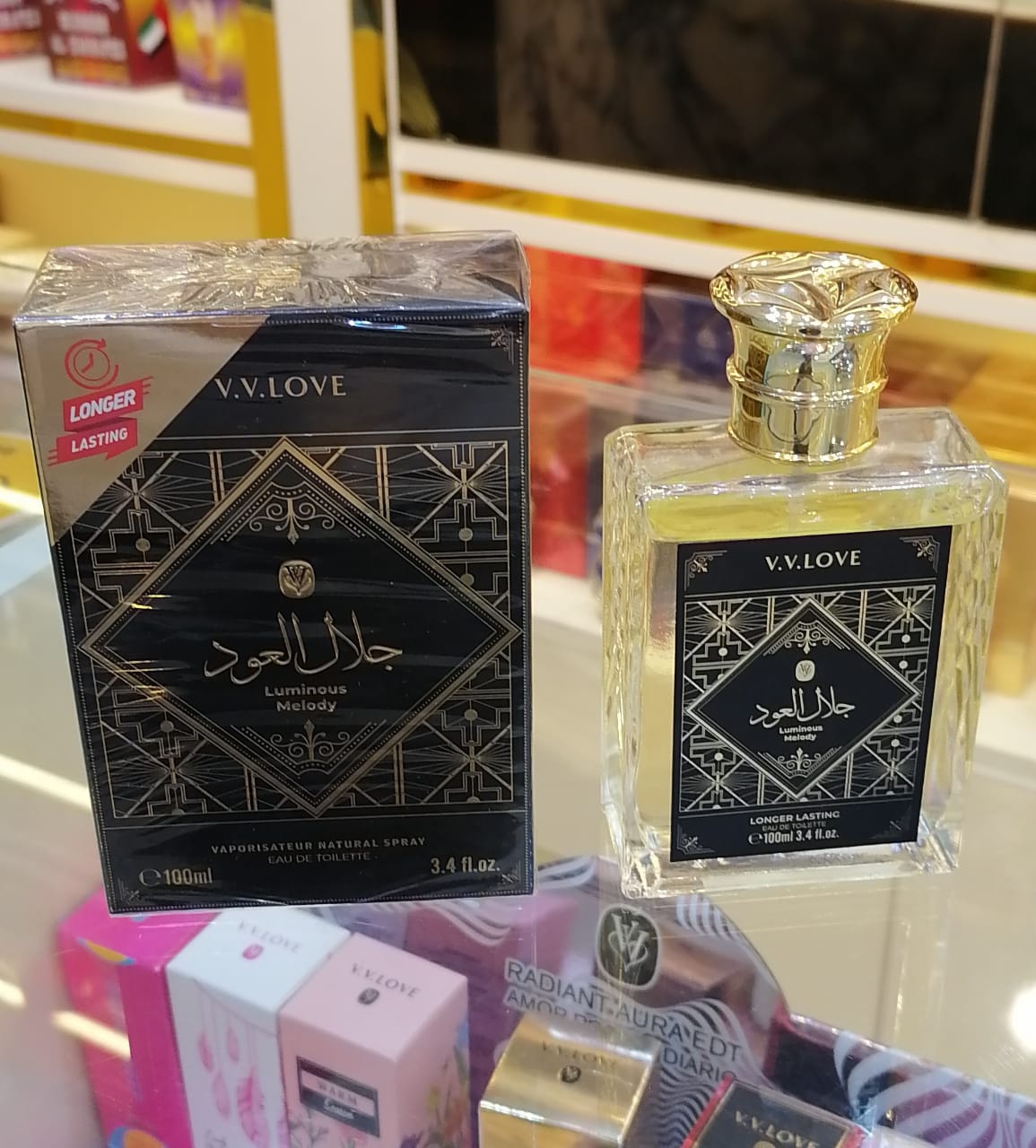 V.V.Love perfume bottle and packaging on a reflective surface with colorful background